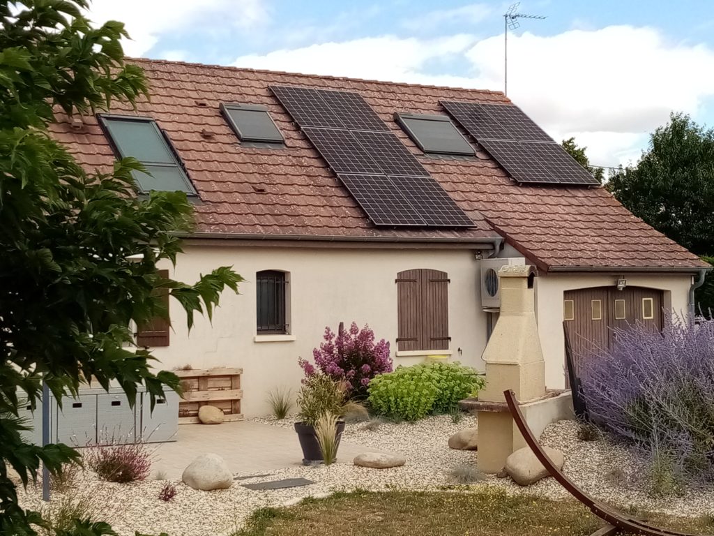 Installation photovoltaïque placé à gauche et droite de la fenêtre de toit.